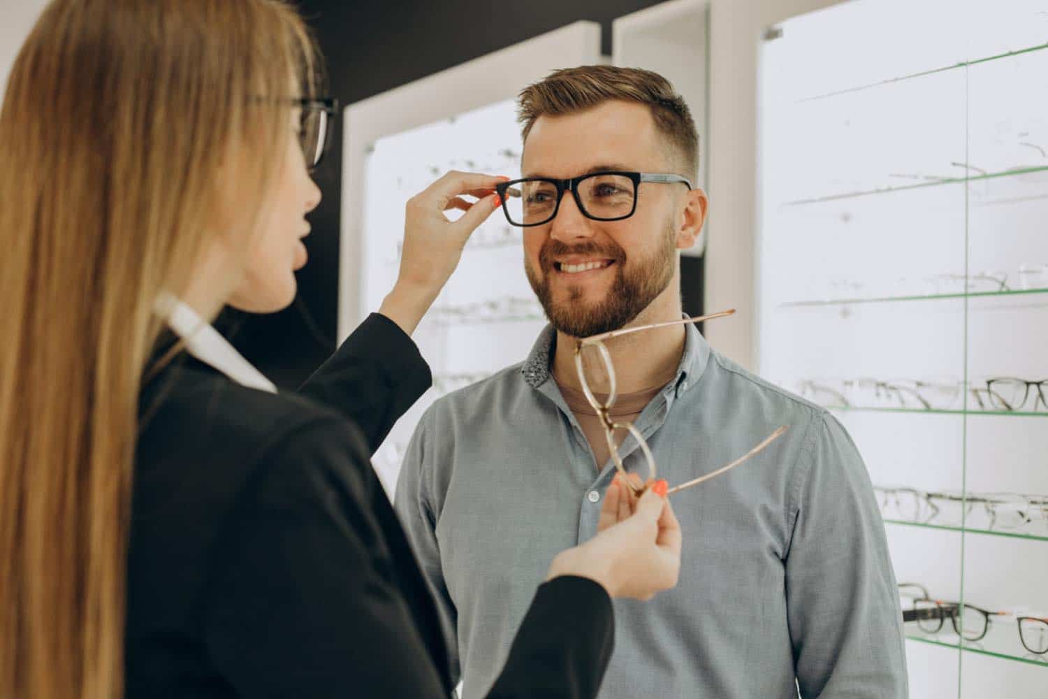 A male customer choosing personalised lenses glasses with help of an optometrist.