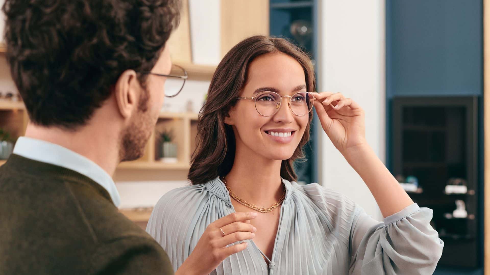Woman smiling while trying on glasses