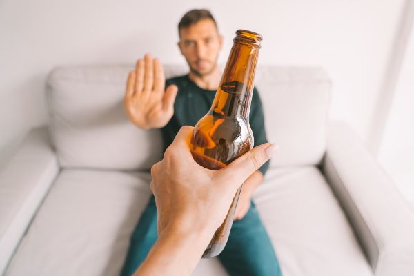 Young man refuse to drink alcohol for good eye health.