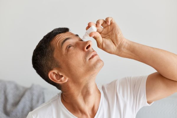 man using eyedrop