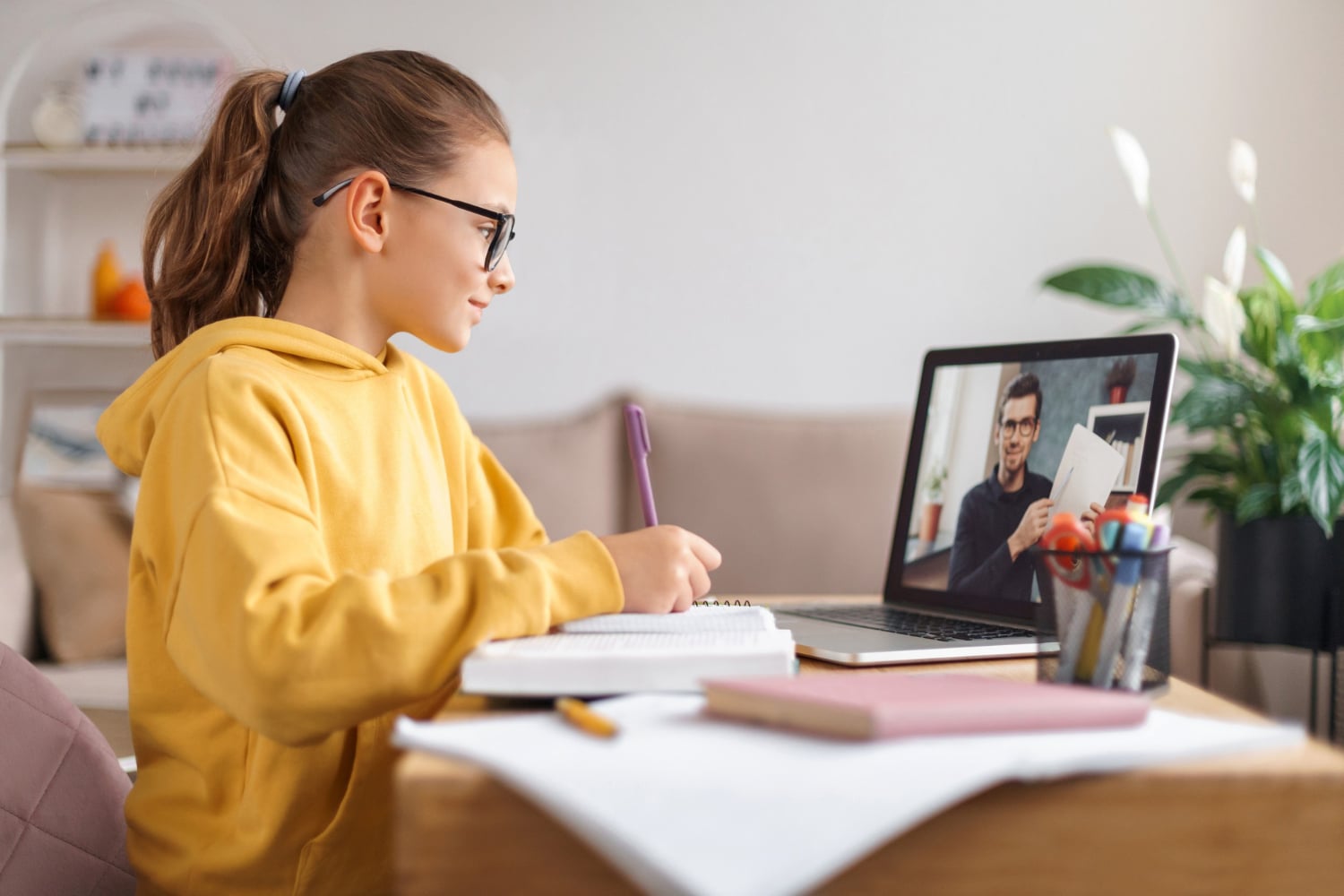 School girl wearing glasses using laptop